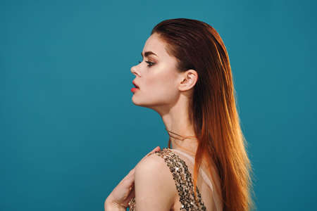 pretty woman in dress side view posing blue background