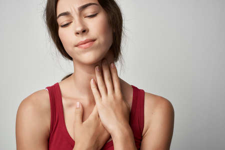 woman in red t-shirt injured finger health problemsの写真素材