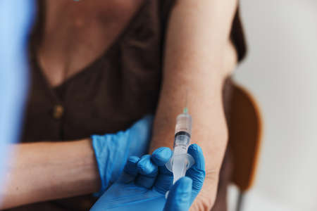 doctor makes an injection in the arm of a patientの写真素材