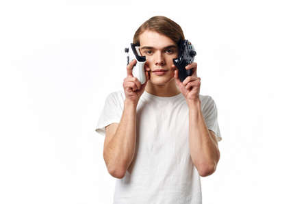 man in white t-shirt with joysticks in hands playing entertainment technology