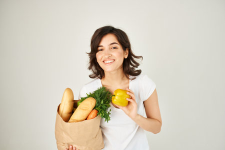 brunette with a package of groceries vegetables deliveryの写真素材