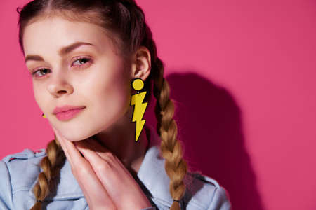 pretty woman with pigtails bright makeup modern style luxury pink backgroundの写真素材