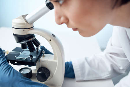 female laboratory assistant looking microscope diagnostics professional scienceの写真素材