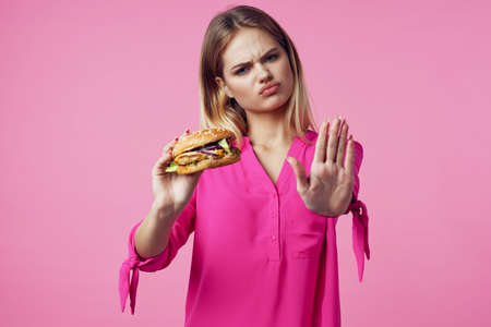 cute cheerful woman in pink shirt hamburger food dietの写真素材