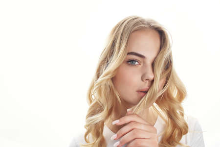 pretty blonde holding hair cosmetics face close-upの写真素材