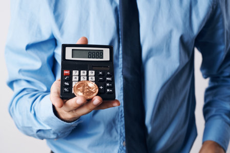 man holding a calculator cryptocurrency bitcoin virtual money investmentの写真素材