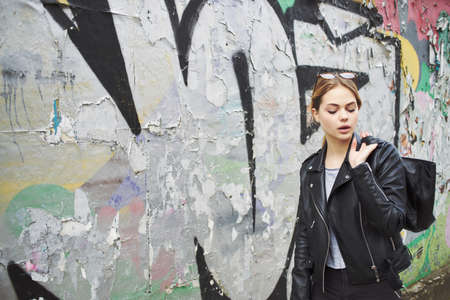 pretty woman walking on the street with a notebook in her hands fashion modern styleの写真素材