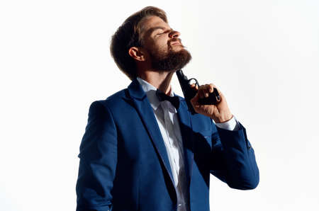male gangster with a gun in hand light background