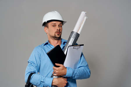 Cheerful male engineer in white helmet construction blueprints work