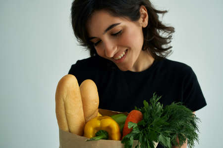 cheerful woman in a black t-shirt food bag vegetables healthy food close-upの写真素材
