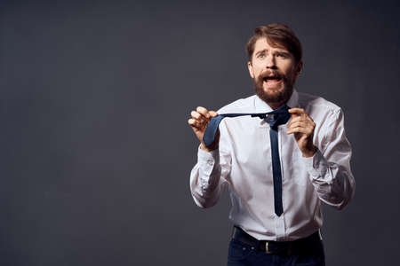 bearded man in a white shirt pulls the tie isolated background
