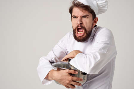 male chef with a cap on his head a saucepan in his hands kitchen cookingの写真素材