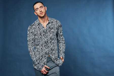handsome man with short hair in shirt fashion posing blue backgroundの写真素材