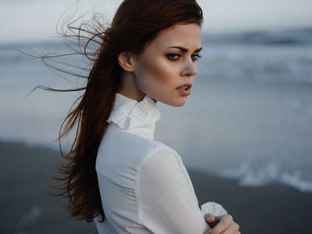 pretty woman in white dress posing luxury walking along the beachの写真素材