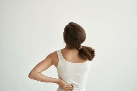 woman in white t-shirt body pain chronic illness medicineの写真素材