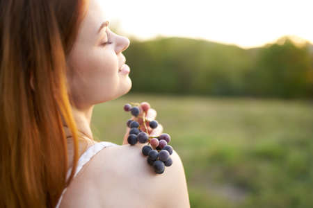 woman with bunch of grapes outdoors leisure walk fresh airの写真素材