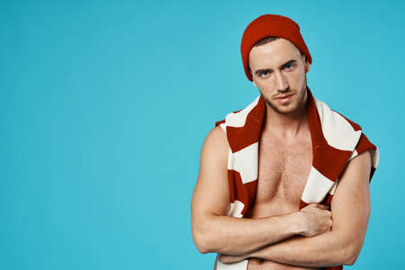 handsome man wearing hat sweater on shoulders posing fashion blue backgroundの写真素材