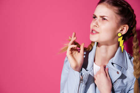 cute glamorous woman with pigtails blue jacket fashion style pink backgroundの写真素材
