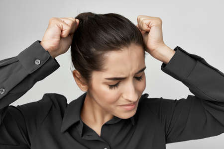 woman in black shirt holding her head health problems emotions depression