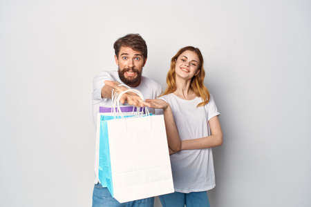 young couple killed in t-shirts with packages in their hands lifestyle shoppingの写真素材