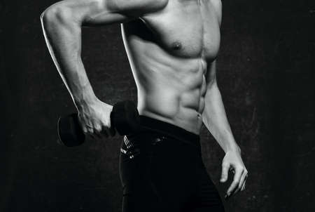 man with a pumped-up torso muscles dumbbells exercise gym