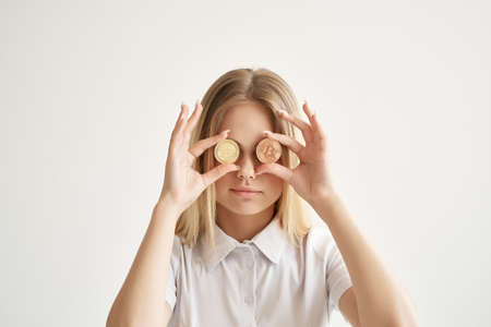 cheerful woman with gold coins cryptocurrency bitcoin light backgroundの写真素材