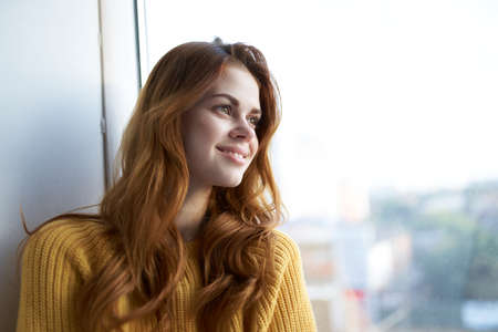 beautiful woman in a yellow sweater at homeの写真素材