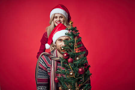 young married couple Christmas tree toys holiday joy red backgroundの写真素材