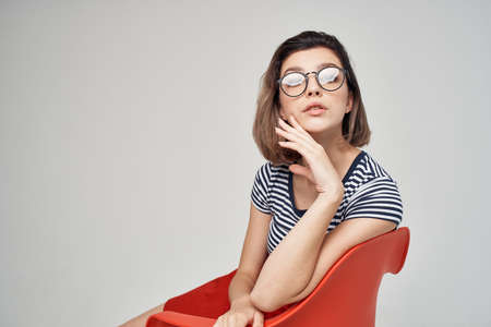 woman with glasses sitting on the red chair cropped view glamorの写真素材