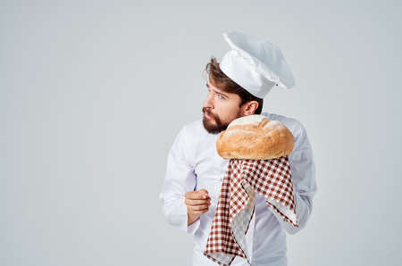 male cook with bread in hand light backgroundの写真素材