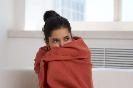 woman at home covered with a blanket cold infectionの写真素材