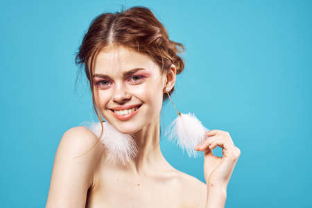 woman with bright makeup fluffy earrings posing close-upの写真素材