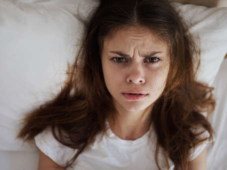 disappointed woman lying in bed dissatisfaction close-upの写真素材