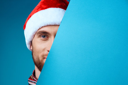 Cheerful man in a santa hat holding a banner holiday isolated backgroundの写真素材
