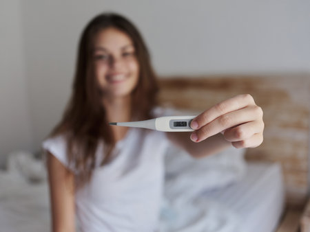 cheerful woman shows a thermometer positive temperatureの写真素材