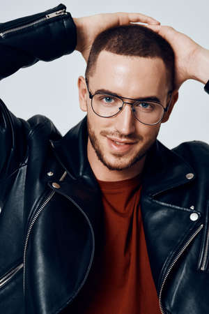 fashionable man in black leather jacket posing self confidenceの写真素材