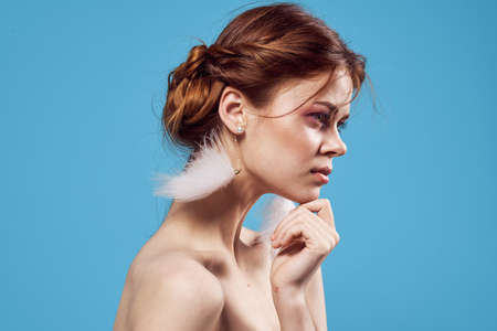 woman bare shoulders fashion jewelry earrings blue backgroundの写真素材