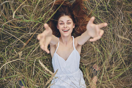 cheerful woman in the field lies on the grass smile vacation summerの写真素材