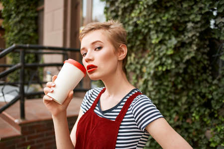 pretty woman outdoors a cup of coffee walk fresh airの写真素材
