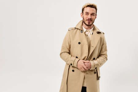 Cheerful man in beige coat autumn style fashionable hairstyle studio