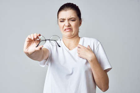 woman in white t-shirt glasses poor eyesight close-upの写真素材