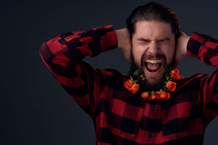 handsome man posing flowers in a beard fashion Lifestyle dark backgroundの写真素材