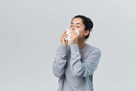 woman wiping her nose with a handkerchief health problems allergy infectionの写真素材