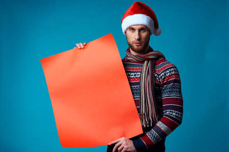 Cheerful man in a christmas Orange mockup Poster blue backgroundの写真素材