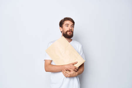 emotional man in a white t-shirt with a paper bag in his hands mocap close-up