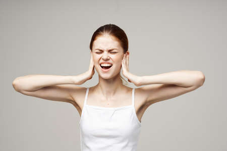 woman poor hearing disorders in white t-shirts isolated backgroundの写真素材