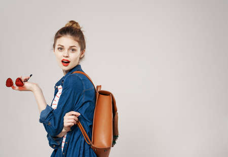 smiling young woman fashion clothes backpack student collegeの写真素材