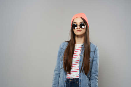 woman in pink hat sunglasses fashion modern style gray background