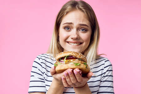 cute blonde girl in striped t-shirt hamburger close-up fast food lifestyle