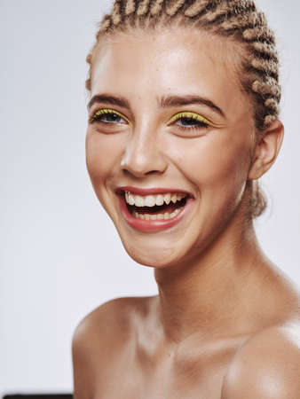 cheerful woman naked shoulders dreadlocks on head isolated background